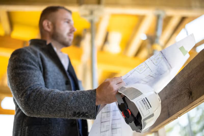 Bauleiter der PAUSCHENWEIN gruppe mit Bauplan auf einer Baustelle